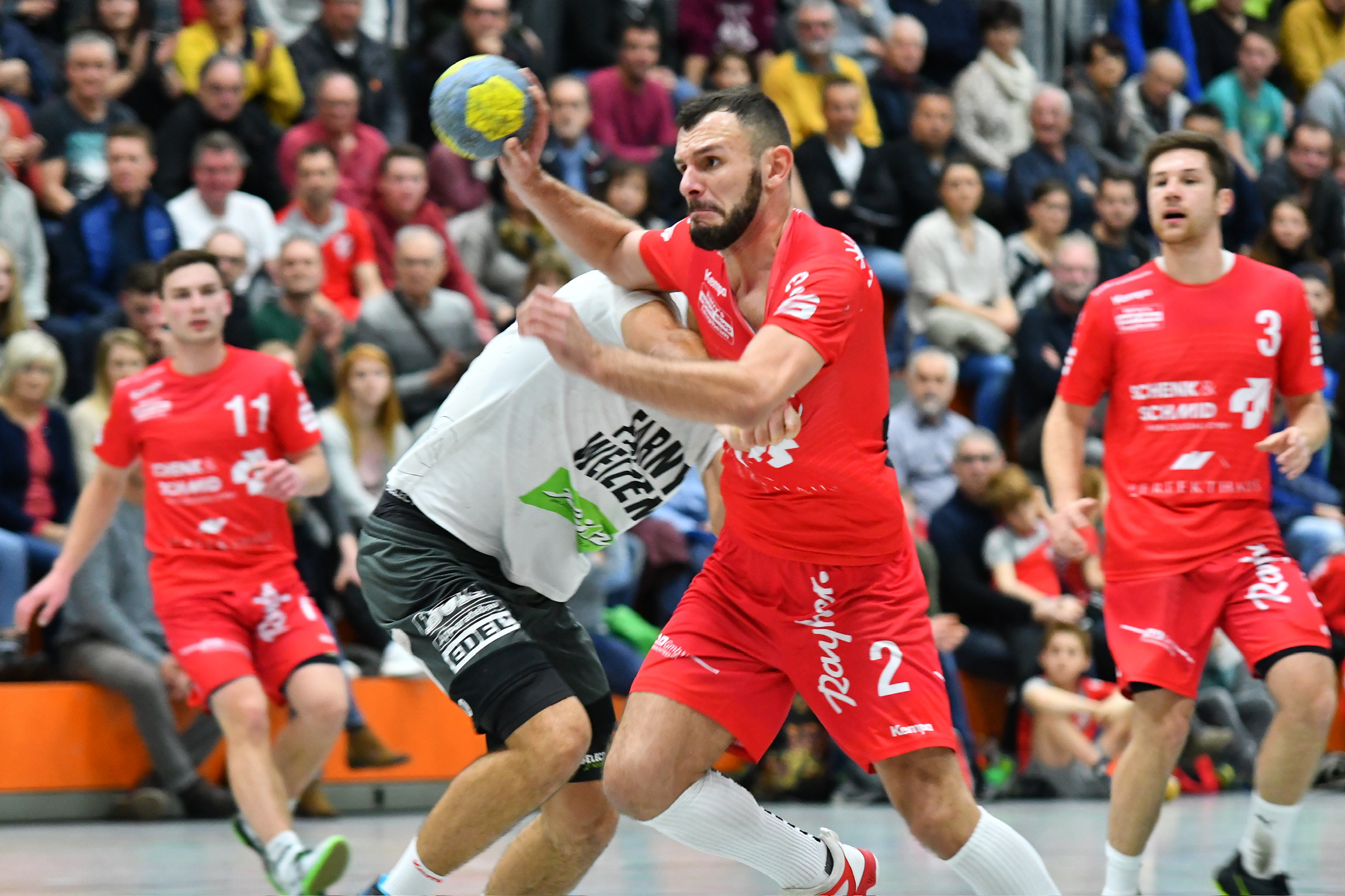 Mit verbissenem Blick kämpft sich der Handballspieler an der Abwehr vorbei